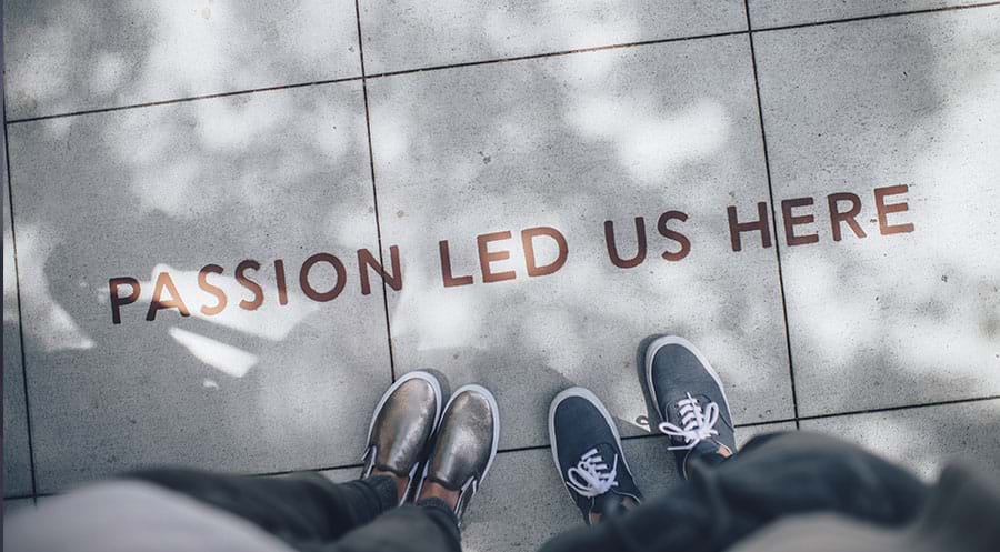 Feet on footpath pointing towards Passion led us here